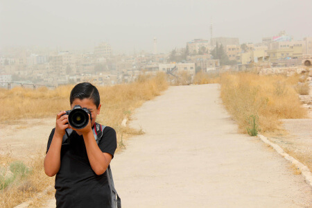 Niño jordano haciendo fotos en la Ciudadela que ver en Ammán