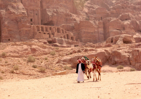 Beduino con su camello frente a las Tumbas Reales que ver en Petra